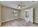 Cozy bedroom with wood-look floors, neutral paint, a window, and an open doorway to another room at 2402 Harper St, Tampa, FL 33605