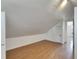 Bright bonus room with sloped ceilings, wood-look flooring, and a door leading to another space at 2402 Harper St, Tampa, FL 33605