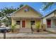 Charming yellow home with a welcoming front porch, complemented by fresh landscaping and a well-maintained yard at 2402 Harper St, Tampa, FL 33605
