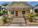 Inviting yellow home featuring a classic front porch and well-manicured landscaping at 2402 Harper St, Tampa, FL 33605