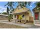 Charming yellow home with a welcoming front porch, complemented by fresh landscaping and a well-maintained yard at 2402 Harper St, Tampa, FL 33605