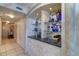 A hallway bar area with granite counter, shelving, and decorative glassware at 2504 Gulf Blvd # 201, Indian Rocks Beach, FL 33785