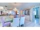 A dining room with decorative lighting, a bar with glass shelving, and a view of an adjacent room at 2504 Gulf Blvd # 201, Indian Rocks Beach, FL 33785