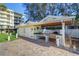 A complete outdoor grilling station with a granite countertop, sink, grill, and refrigerator at 2504 Gulf Blvd # 201, Indian Rocks Beach, FL 33785