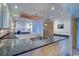Open kitchen featuring granite countertops, white cabinetry, and modern stainless steel appliances at 2504 Gulf Blvd # 201, Indian Rocks Beach, FL 33785