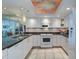 Kitchen with granite counters, white cabinets, and adjacent living area view at 2504 Gulf Blvd # 201, Indian Rocks Beach, FL 33785