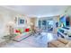 Bright living room with tile floors, ocean views, comfortable seating, and a modern entertainment center at 2504 Gulf Blvd # 201, Indian Rocks Beach, FL 33785