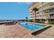 Beautiful community pool area with lounging chairs, hot tub, and direct ocean views at 2504 Gulf Blvd # 201, Indian Rocks Beach, FL 33785