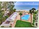 Aerial view of a pool near the beach, with sun loungers and palm trees, creating a relaxing tropical oasis at 2504 Gulf Blvd # 201, Indian Rocks Beach, FL 33785