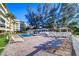 Exterior view of a communal pool with lounge chairs and nearby building with lush landscaping at 2504 Gulf Blvd # 201, Indian Rocks Beach, FL 33785