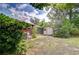 View of a home's backyard featuring a shed, a screened-in patio, and mature trees at 2524 Laurelwood Ln, Valrico, FL 33596