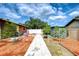 View of a well-maintained backyard with a shed, pavers, and lush landscaping under a partly cloudy sky at 2524 Laurelwood Ln, Valrico, FL 33596