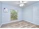 Bright bedroom with wood-look flooring, ceiling fan, and window providing natural light at 2524 Laurelwood Ln, Valrico, FL 33596