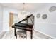 Close up of piano and stainless refrigerator near the dining area with wood floors and neutral walls at 2524 Laurelwood Ln, Valrico, FL 33596