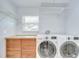 Laundry room showcasing a washer, dryer, cabinets and shelving at 2524 Laurelwood Ln, Valrico, FL 33596