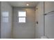 Walk-in shower features white tile and gray hexagonal tile flooring at 2608 Browning St, Sarasota, FL 34237