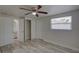 Well-lit bedroom features a ceiling fan, wood-look floors, and a view into the ensuite bathroom at 2608 Browning St, Sarasota, FL 34237