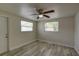 Airy bedroom with wood-look floors, two windows, and a ceiling fan with lighting at 2608 Browning St, Sarasota, FL 34237