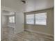 Bright bedroom with wood-look flooring, neutral paint, two windows, and a view into the next room at 2608 Browning St, Sarasota, FL 34237