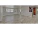 A bright living room with wood-look floors, neutral walls, and a view into the adjacent, modern kitchen at 2608 Browning St, Sarasota, FL 34237