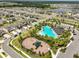 This community's aerial view highlights the pool, playground, and residences near green spaces and lakes at 2858 Star Anise Ln, Wimauma, FL 33598