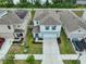 Aerial view of the home with landscaped front yard and a long driveway leading to the garage at 2858 Star Anise Ln, Wimauma, FL 33598