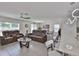 Spacious living room with tile flooring, modern lighting, and comfortable seating arrangement at 2858 Star Anise Ln, Wimauma, FL 33598