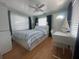 Bright bedroom featuring a bed with blue and white striped linens, wood flooring, a ceiling fan and an exterior door at 3031 56Th S St, Gulfport, FL 33707