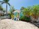 Charming light blue home with white trim, manicured front yard, and tropical landscaping at 3031 56Th S St, Gulfport, FL 33707
