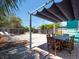 Backyard patio featuring a wooden dining table set on a brick paved patio, a shade structure, and a fenced yard at 3031 56Th S St, Gulfport, FL 33707