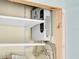 Close-up of an EcoSmart tankless water heater with white shelving installed around and below it at 3031 56Th S St, Gulfport, FL 33707