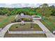 Wide aerial view of the property with its expansive lot, long driveway, and secure fencing at 30703 San An Rd, San Antonio, FL 33576