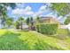 A well-manicured lawn and verdant shrubbery define the spacious backyard, complemented by a charming home exterior at 311 Parsons Woods Dr, Seffner, FL 33584