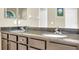 Bathroom double vanity features granite countertop and dark cabinets at 311 Parsons Woods Dr, Seffner, FL 33584