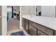 Bathroom vanity with double sinks, a dark vanity, and a view into an adjacent bedroom at 311 Parsons Woods Dr, Seffner, FL 33584