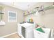 Well-lit laundry room is equipped with washer, dryer, utility sink, and shelving at 311 Parsons Woods Dr, Seffner, FL 33584