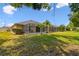 A well-maintained backyard features a screened lanai, mature landscaping, and a spacious lawn for outdoor enjoyment at 31105 Whitlock Dr, Wesley Chapel, FL 33543
