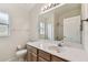 Bathroom with a wooden vanity, modern lighting, and a large mirror, creating an open and airy space at 31105 Whitlock Dr, Wesley Chapel, FL 33543