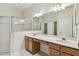 Bathroom featuring double sinks, large vanity area, framed mirror, and glass-enclosed shower at 31105 Whitlock Dr, Wesley Chapel, FL 33543