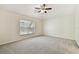 Bright bedroom with carpet flooring, ceiling fan, and a large window with natural light at 31105 Whitlock Dr, Wesley Chapel, FL 33543
