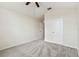 A carpeted bedroom is complete with a ceiling fan and two doorways leading to other rooms at 31105 Whitlock Dr, Wesley Chapel, FL 33543