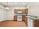 Kitchen featuring wooden cabinets, laminate flooring, granite countertops, and stainless steel appliances at 31105 Whitlock Dr, Wesley Chapel, FL 33543
