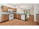 Cozy kitchen featuring wood cabinets, granite countertops, and white appliances at 31105 Whitlock Dr, Wesley Chapel, FL 33543