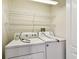 Clean laundry room features a white washer and dryer with wire rack shelving above at 31105 Whitlock Dr, Wesley Chapel, FL 33543