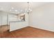 Bright open living space with wood floors, a chandelier, and partial view of the kitchen at 31105 Whitlock Dr, Wesley Chapel, FL 33543