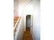 View of a staircase with wood treads, white risers and a railing, with a door open to a storage area at 3276 38Th S Way # D, St Petersburg, FL 33711