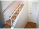 A well-lit staircase with wooden steps, white risers, and a white railing provides access to upper level at 3276 38Th S Way # D, St Petersburg, FL 33711