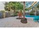 A backyard with pavers, landscaping, a mature palm tree, a privacy fence, and a view of the pool at 330 Pineapple St, Tarpon Springs, FL 34689