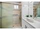 Bathroom featuring walk-in shower with glass doors, modern vanity with vessel sink and tiled accent at 330 Pineapple St, Tarpon Springs, FL 34689