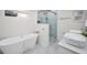 Bright bathroom featuring a standalone tub, glass enclosed shower, and stylish white vanity with dual sinks at 330 Pineapple St, Tarpon Springs, FL 34689